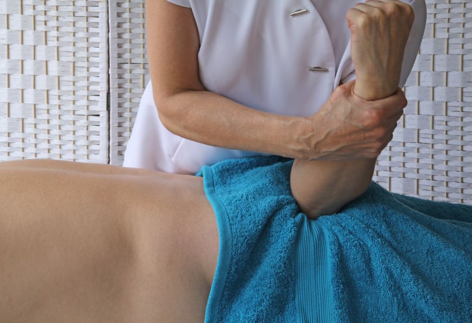 Mujer terapeuta aplica presión con el codo en el músculo glúteo